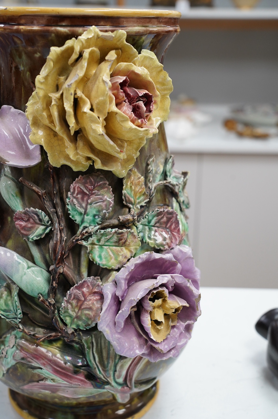 A large majolica floral decorated vase, 39cm. Condition - fair, several chips